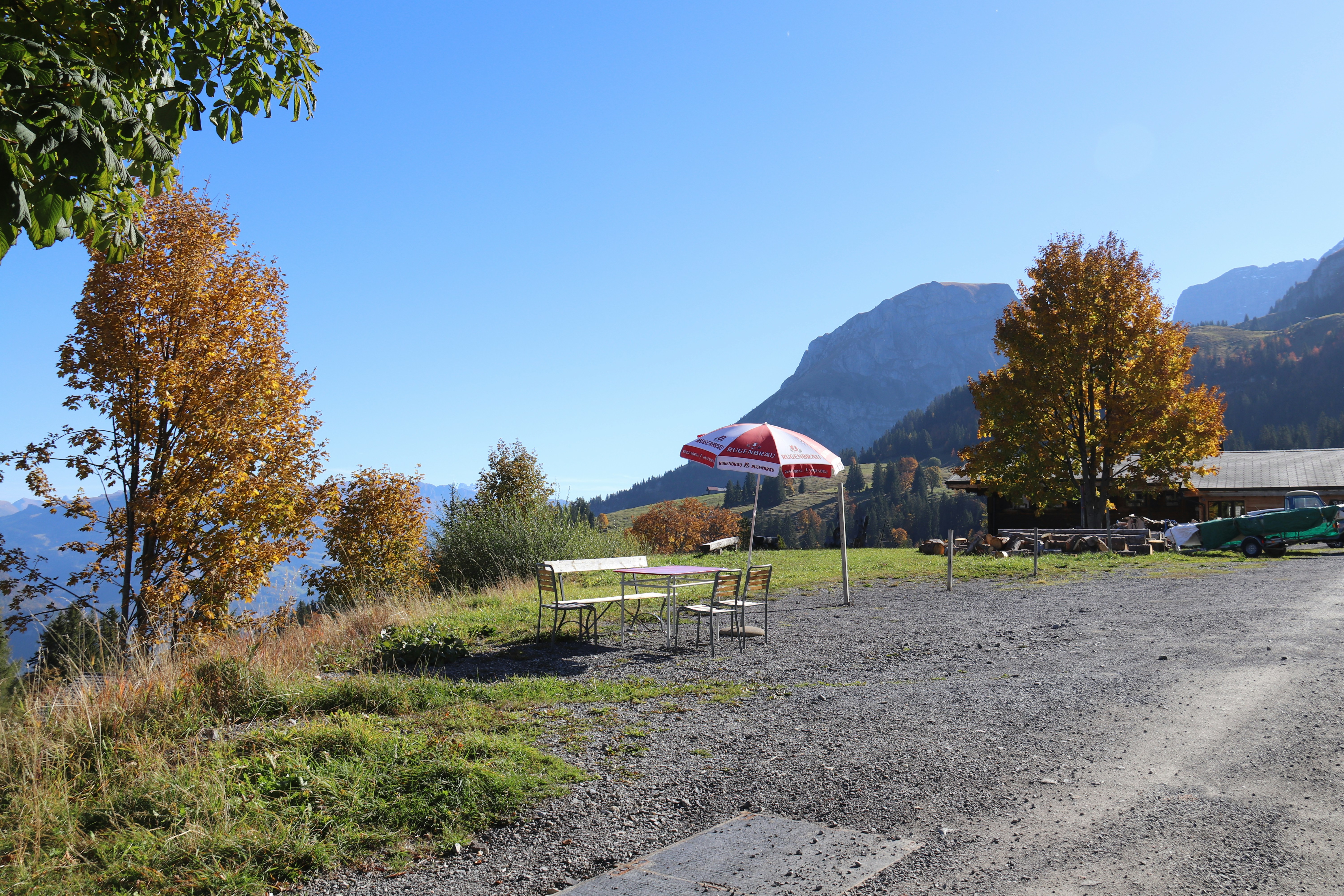A picnic table and umbrella on a gravel road photo Free Brienz Image