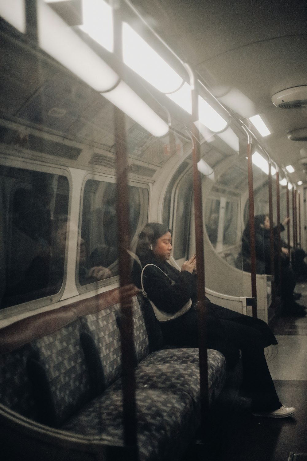 a woman is sitting on a train looking out the window