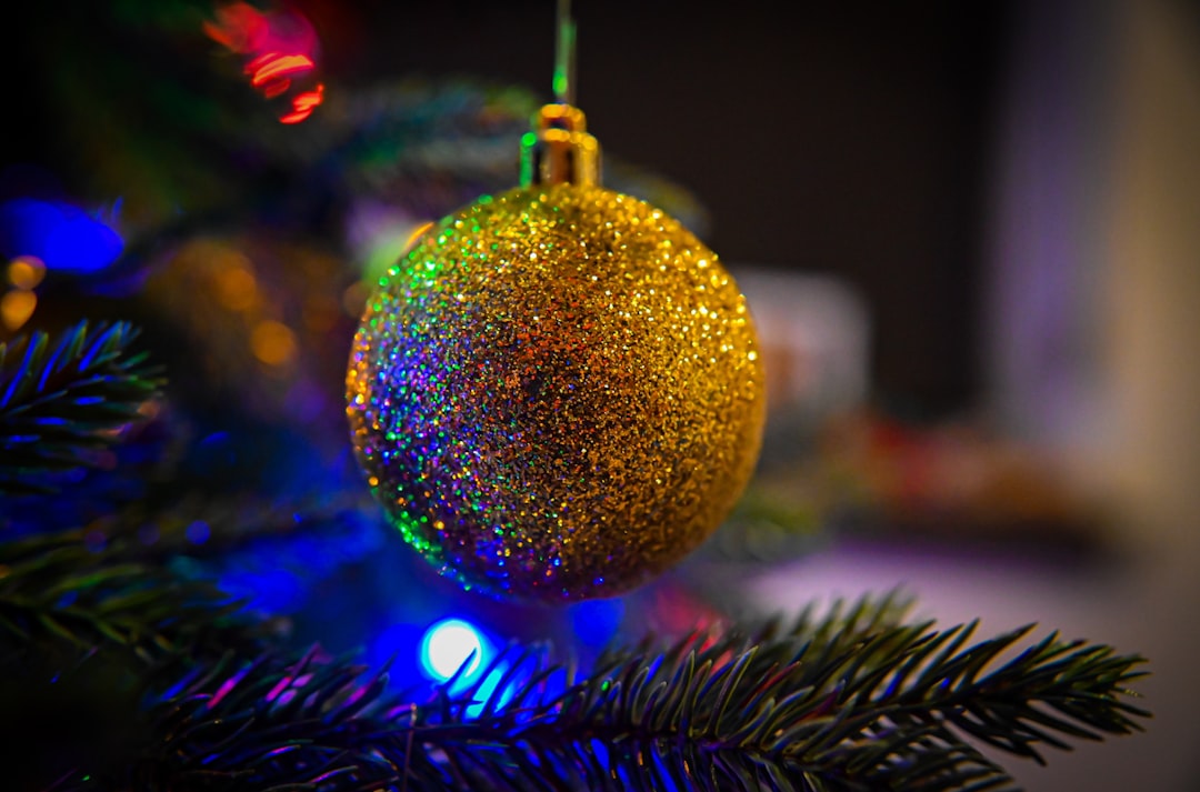 a close up of a christmas ornament on a tree, Close up sparkly gold ornament
