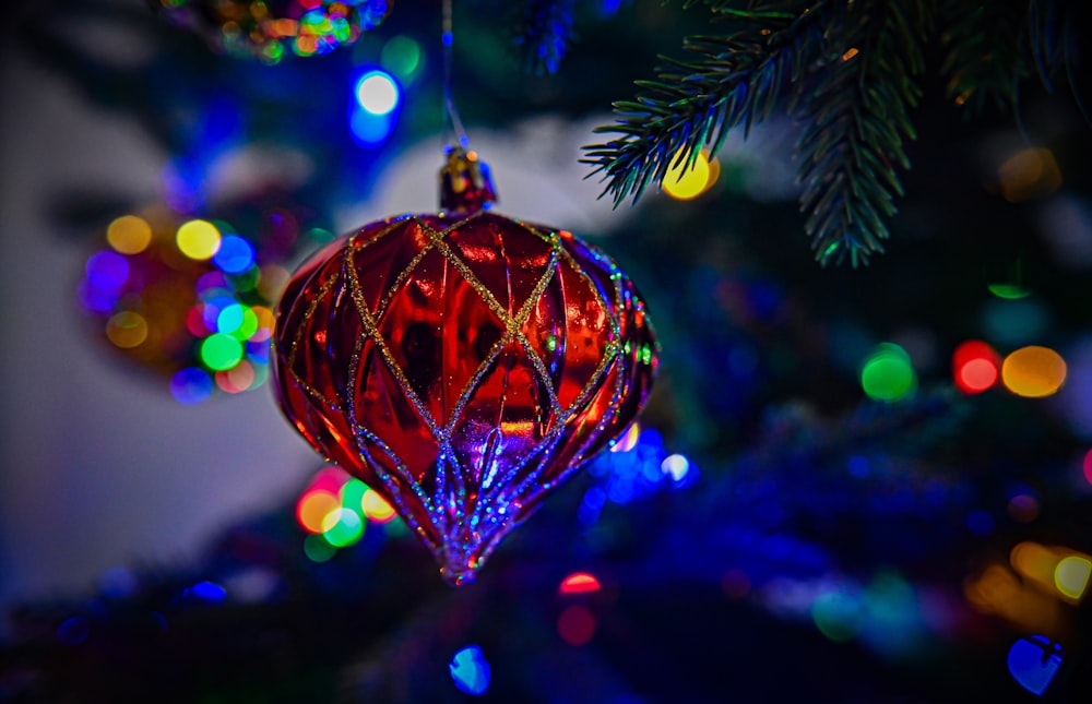 a red ornament hanging from a christmas tree