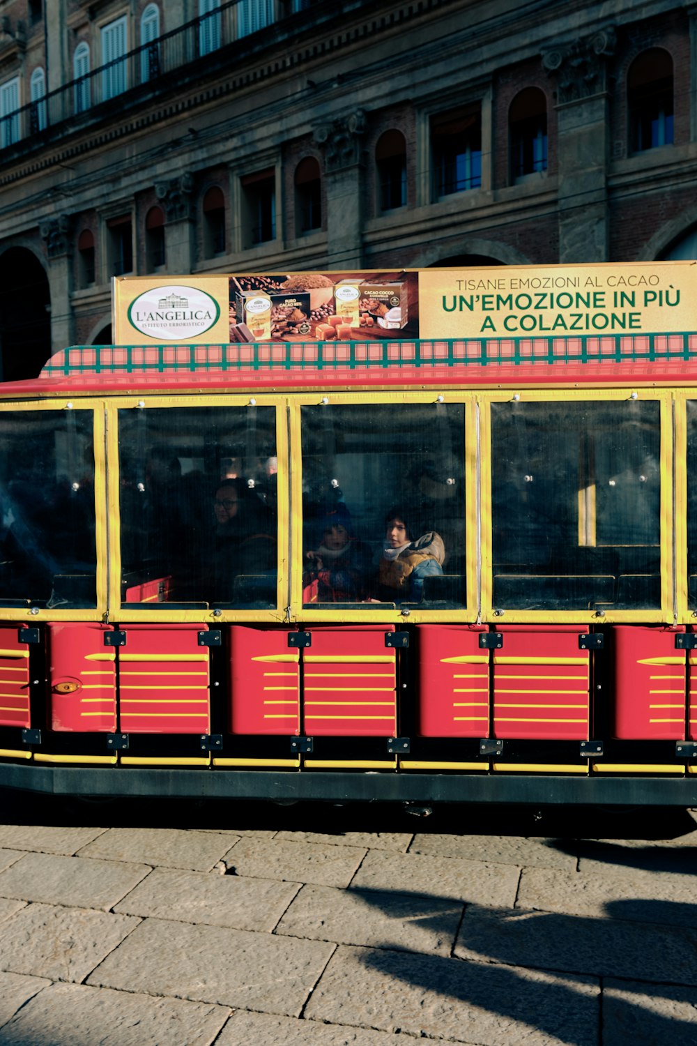 a red and yellow trolley on a city street