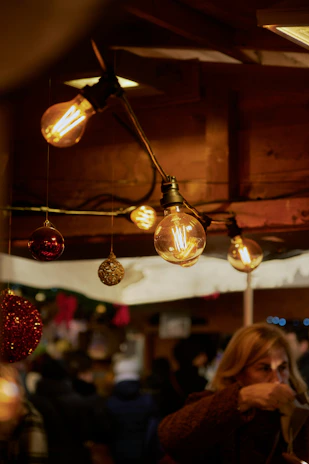 Warm, festive ambiance of a Christmas market with twinkling lights and happy customers enjoying tarte flambée.
