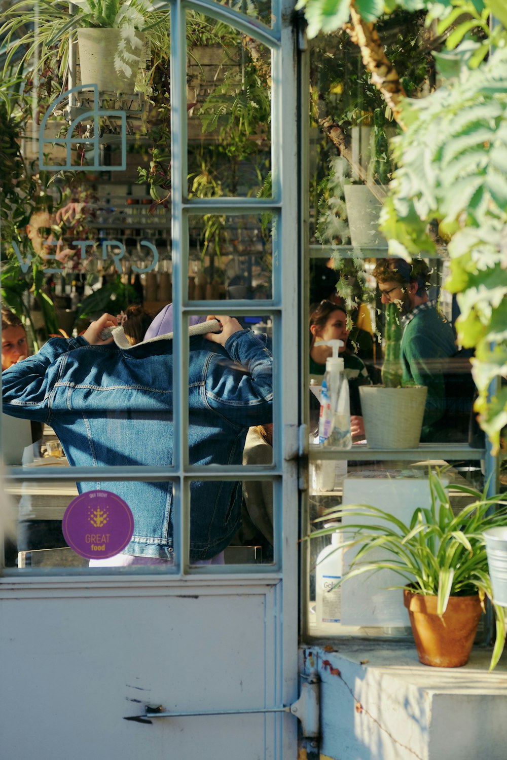 a person sitting at a table in a greenhouse
