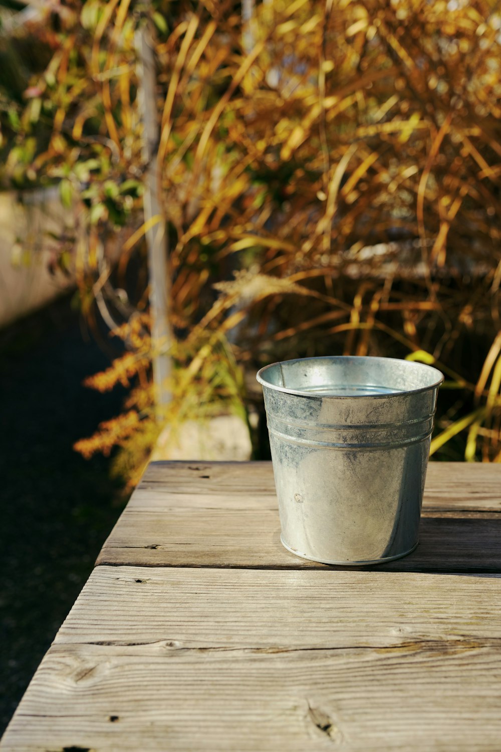 a metal cup sitting on top of a wooden table