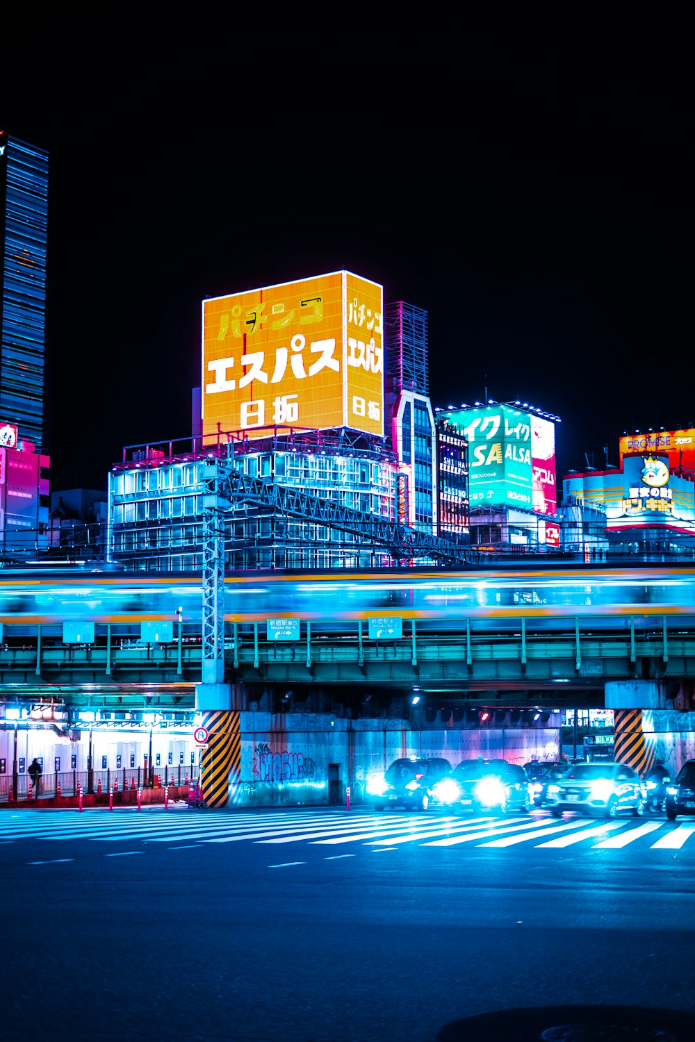 a city at night with neon lights and buildings