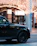 A sleek black SUV parked near the vibrant Jemaa el-Fnaa square at sunset.