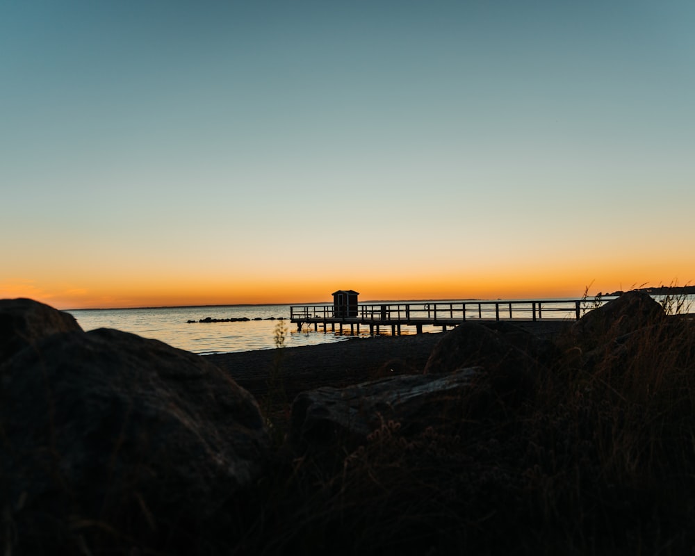 une personne debout sur une plage au coucher du soleil