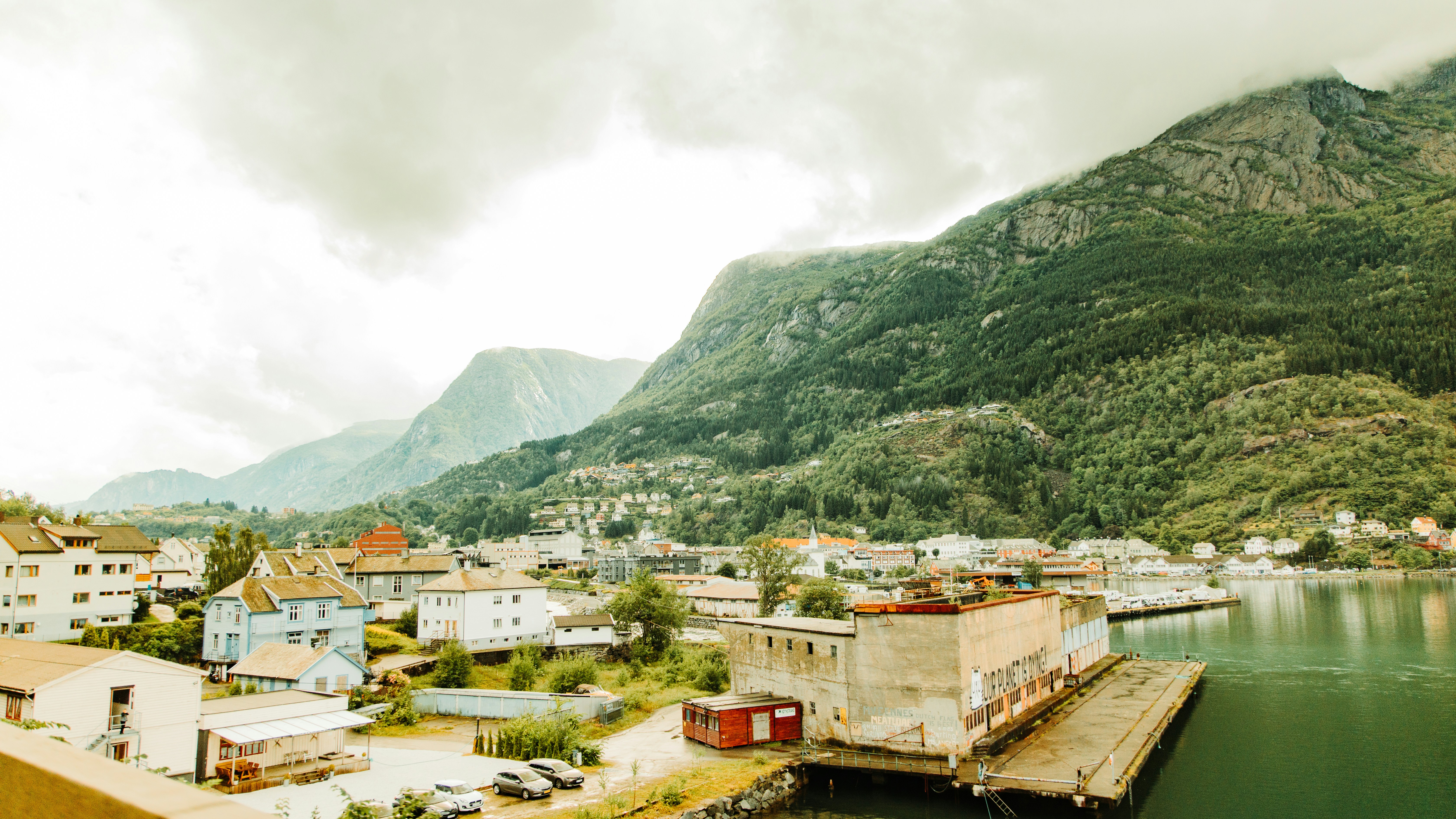 a body of water surrounded by mountains and houses, Norwegian city Odda in mountains