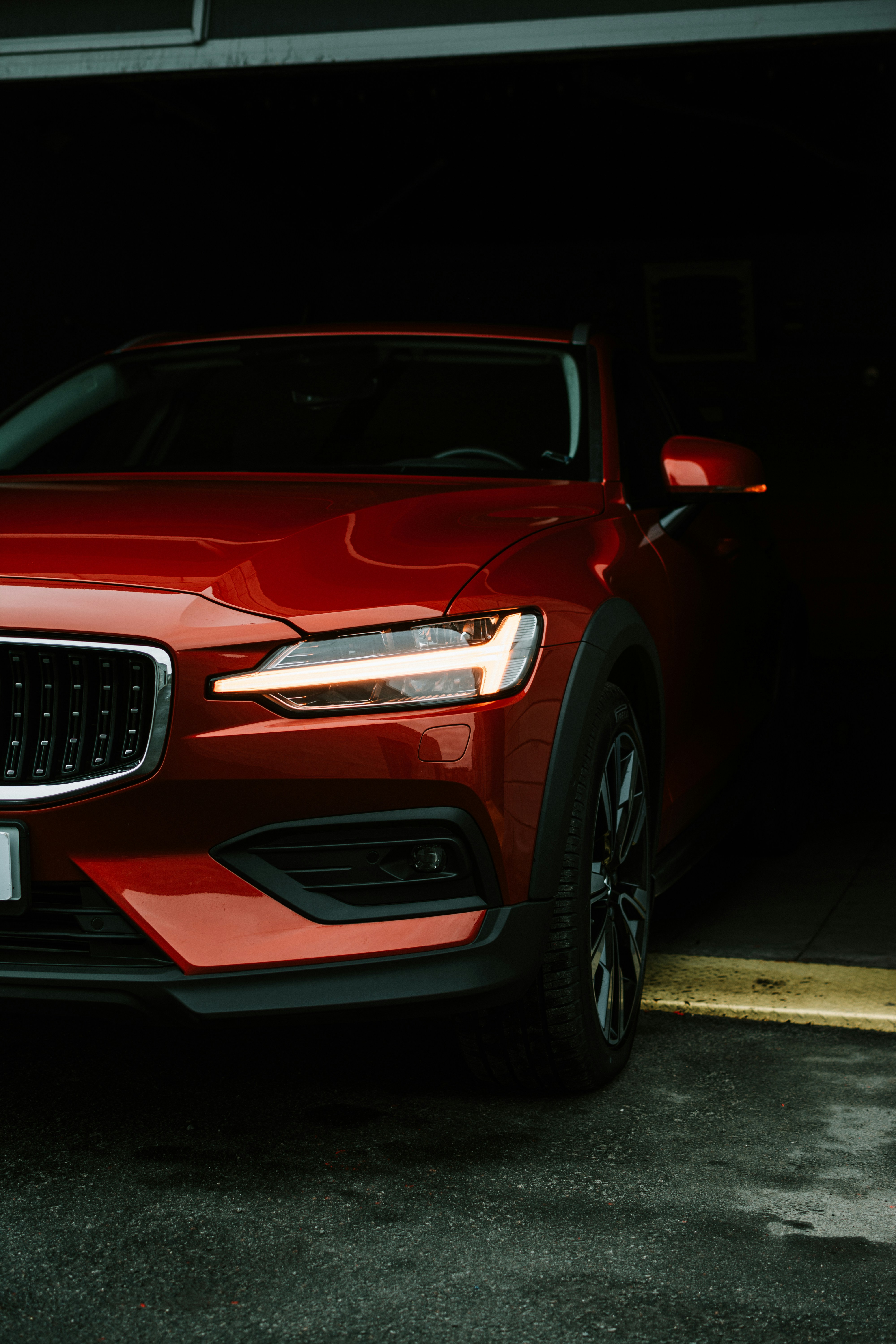 a red volvo car parked in a garage