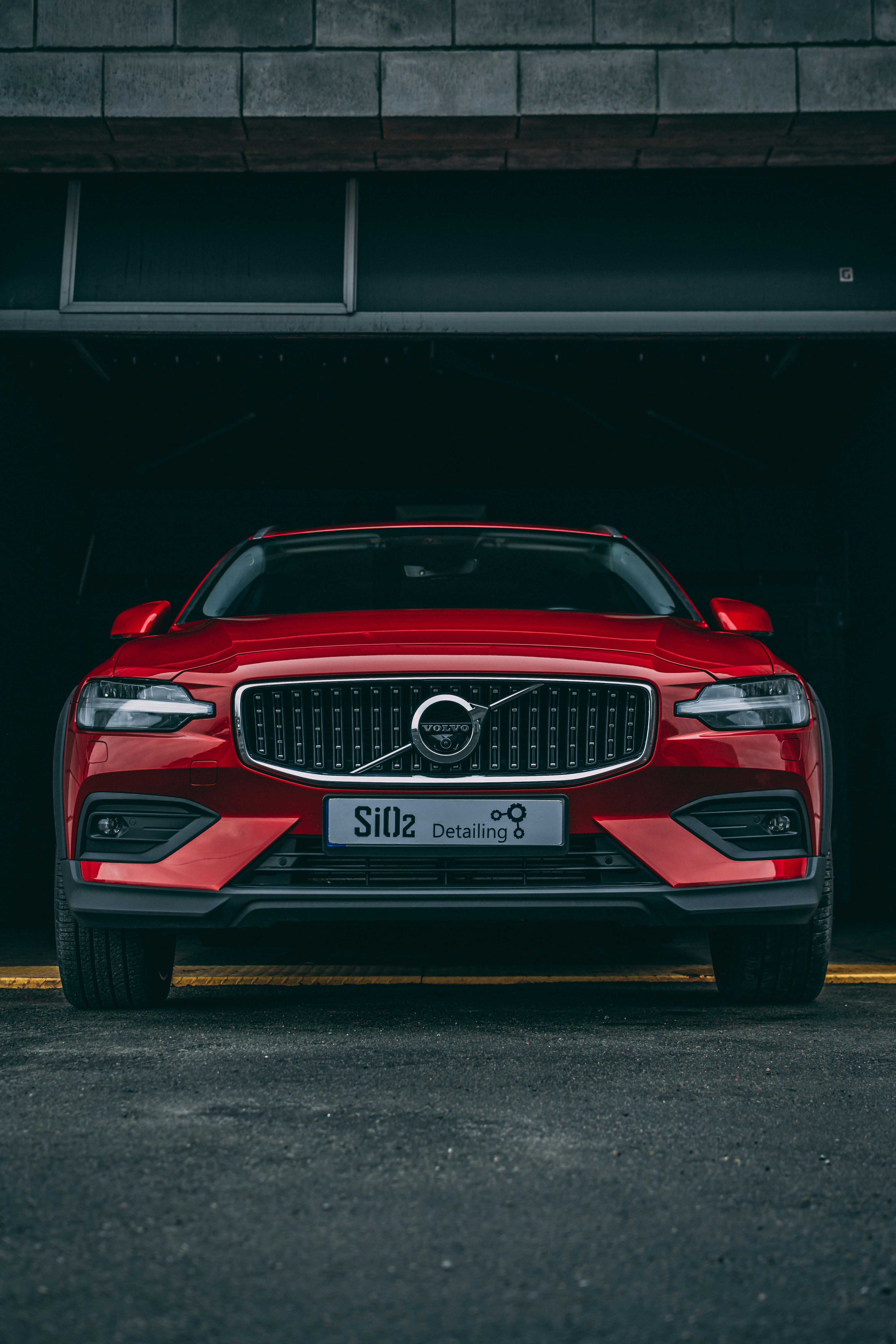 a red volvo suv parked in a garage