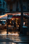 A cozy café terrace in France filled with people enjoying their coffee.