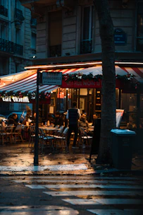 A cozy urban café terrace in Dijon at sunset, inviting casual encounters.