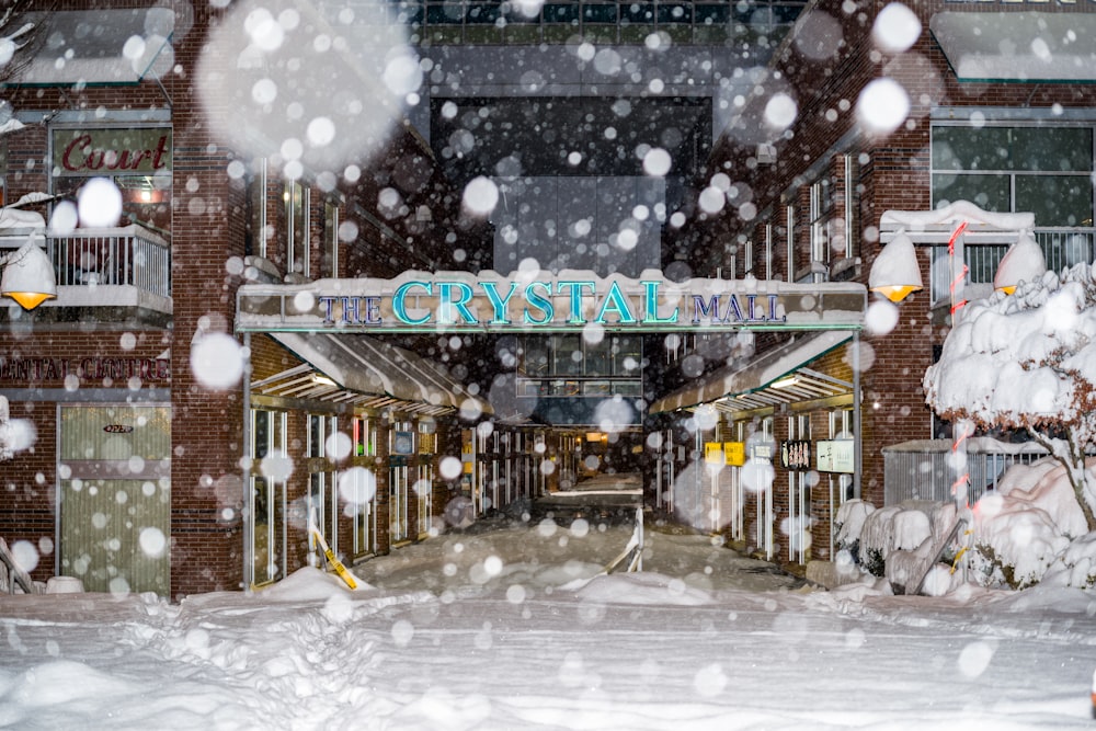 a snow covered street with a building in the background