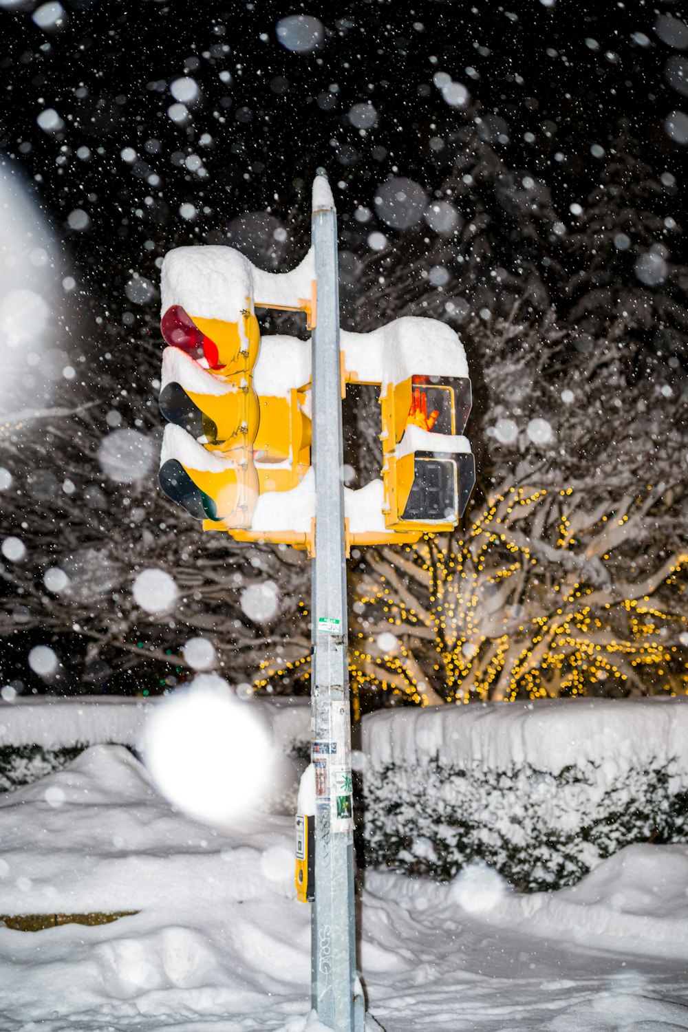 a parking meter covered in snow at night