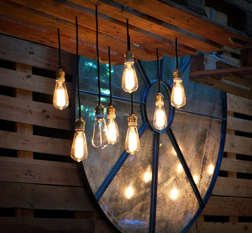 a bunch of light bulbs hanging from a wooden wall