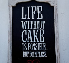 a sign on the side of a building that says life without cake is possible but