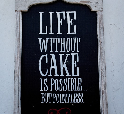a sign on the side of a building that says life without cake is possible but