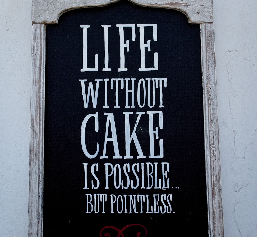 a sign on the side of a building that says life without cake is possible but