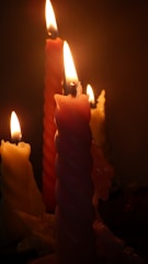Four lit candles with twisted designs create a warm and serene atmosphere. The soft, glowing flames flicker gently, casting a subtle glow on the surrounding area.