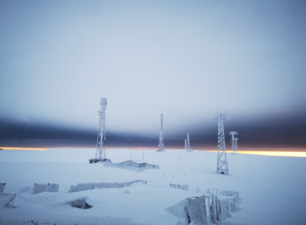 a group of cell towers sitting in the middle of a snow covered field