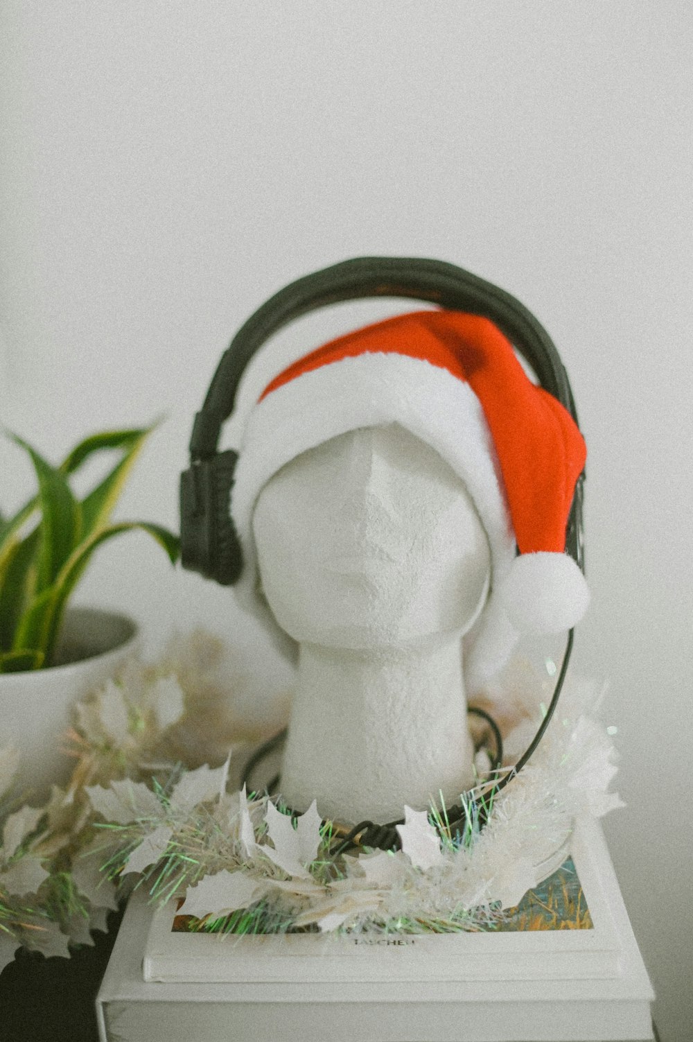 uma cabeça de manequim branco usando um chapéu de Papai Noel vermelho e branco