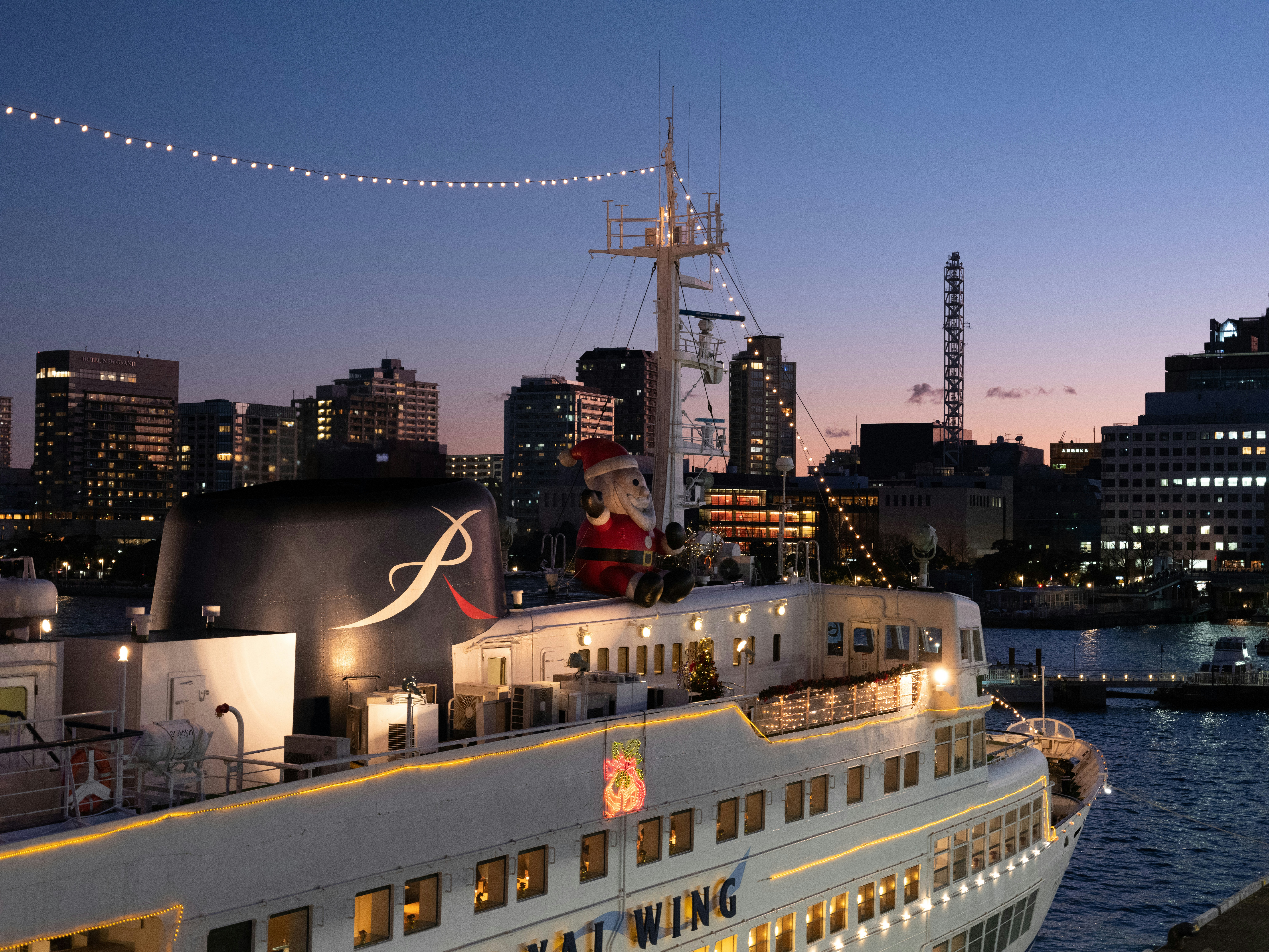 a large cruise ship in the water with a city in the background