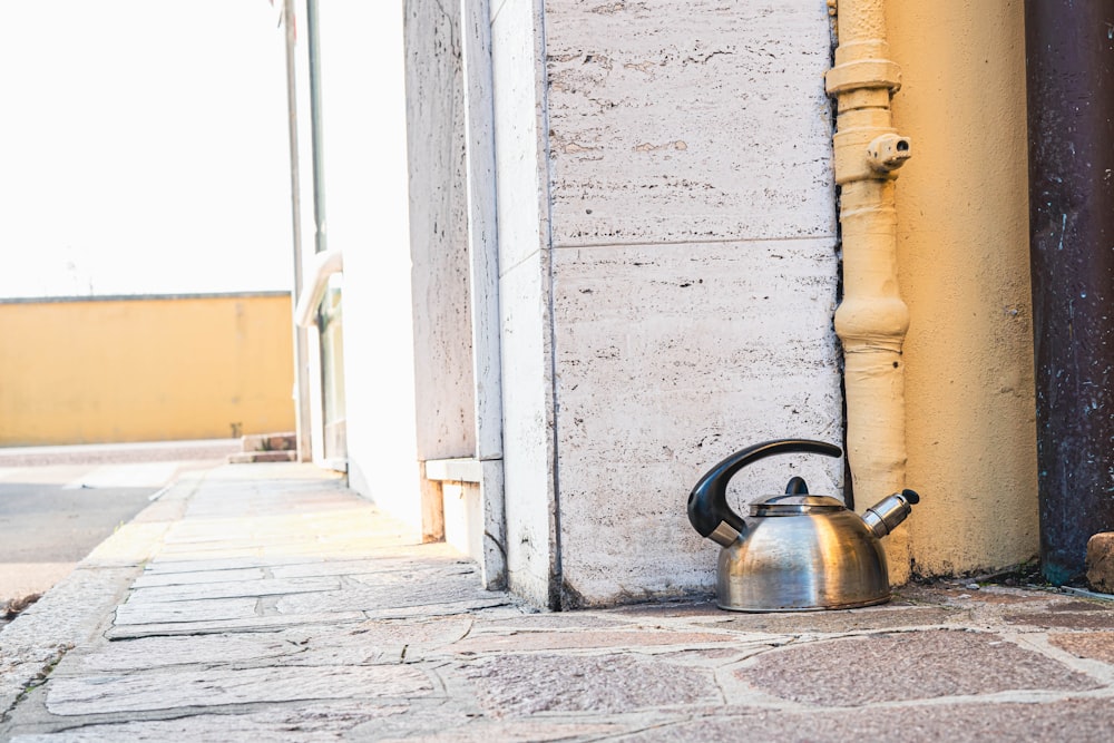 a tea kettle sitting on the side of a building