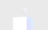 A minimalistic 3D letter 'R' with a subtle pastel gradient, placed on top of a simple white pedestal against a light gray background.