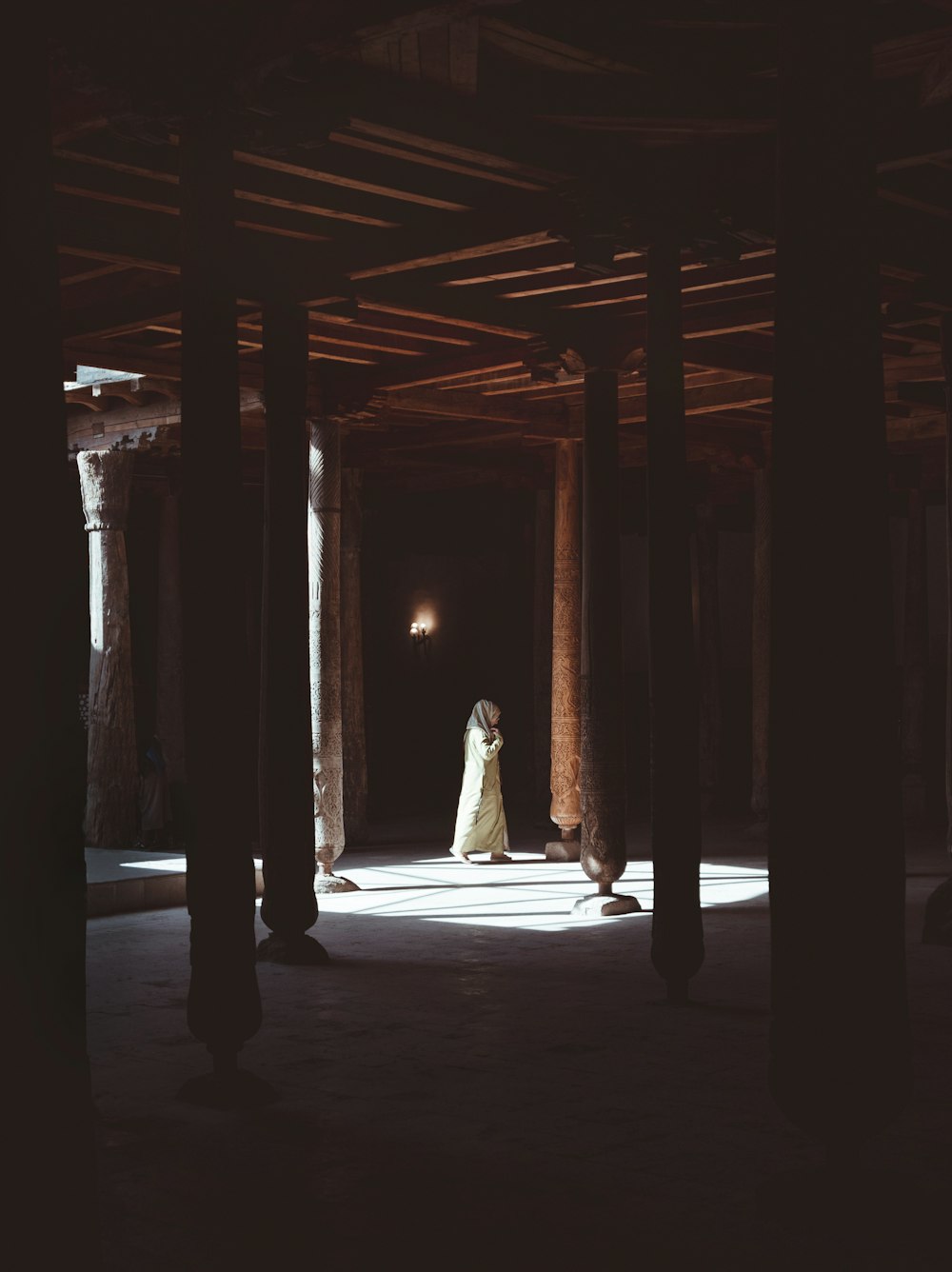 a woman in a long white dress standing in a dark room