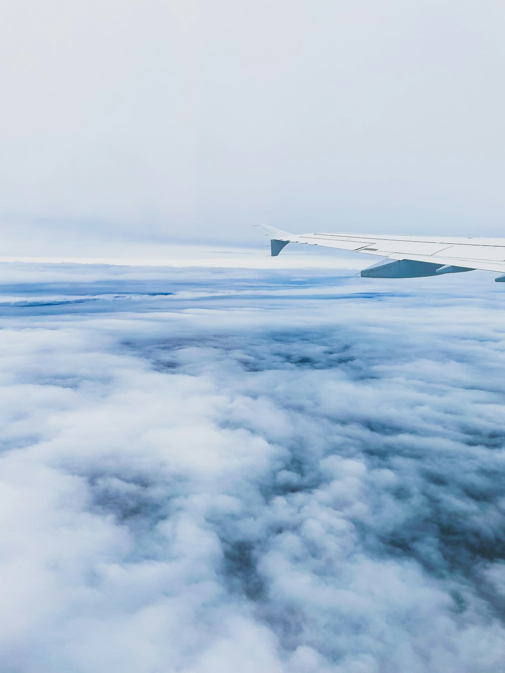 Blick auf den Flügel eines Flugzeugs über den Wolken