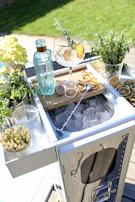 An elegant bar cart set up with glassware and fresh herbs, ready for entertaining.