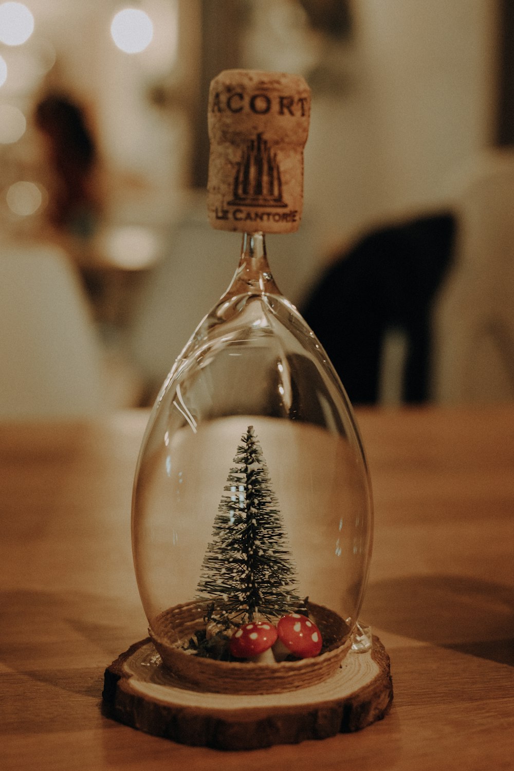 a glass bottle with a christmas tree inside of it