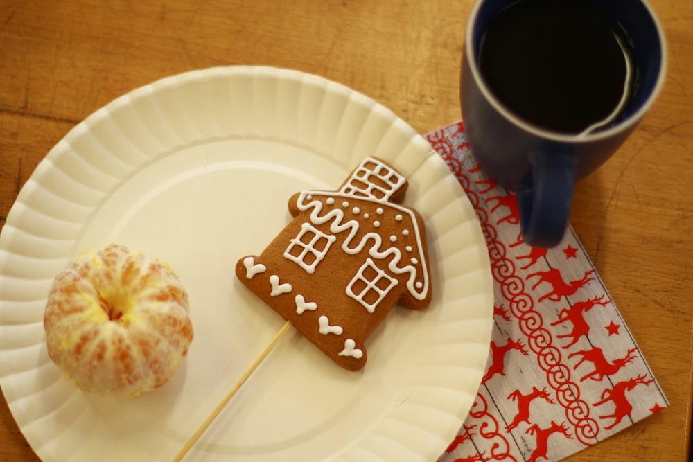 a white plate topped with a cookie and a cup of coffee