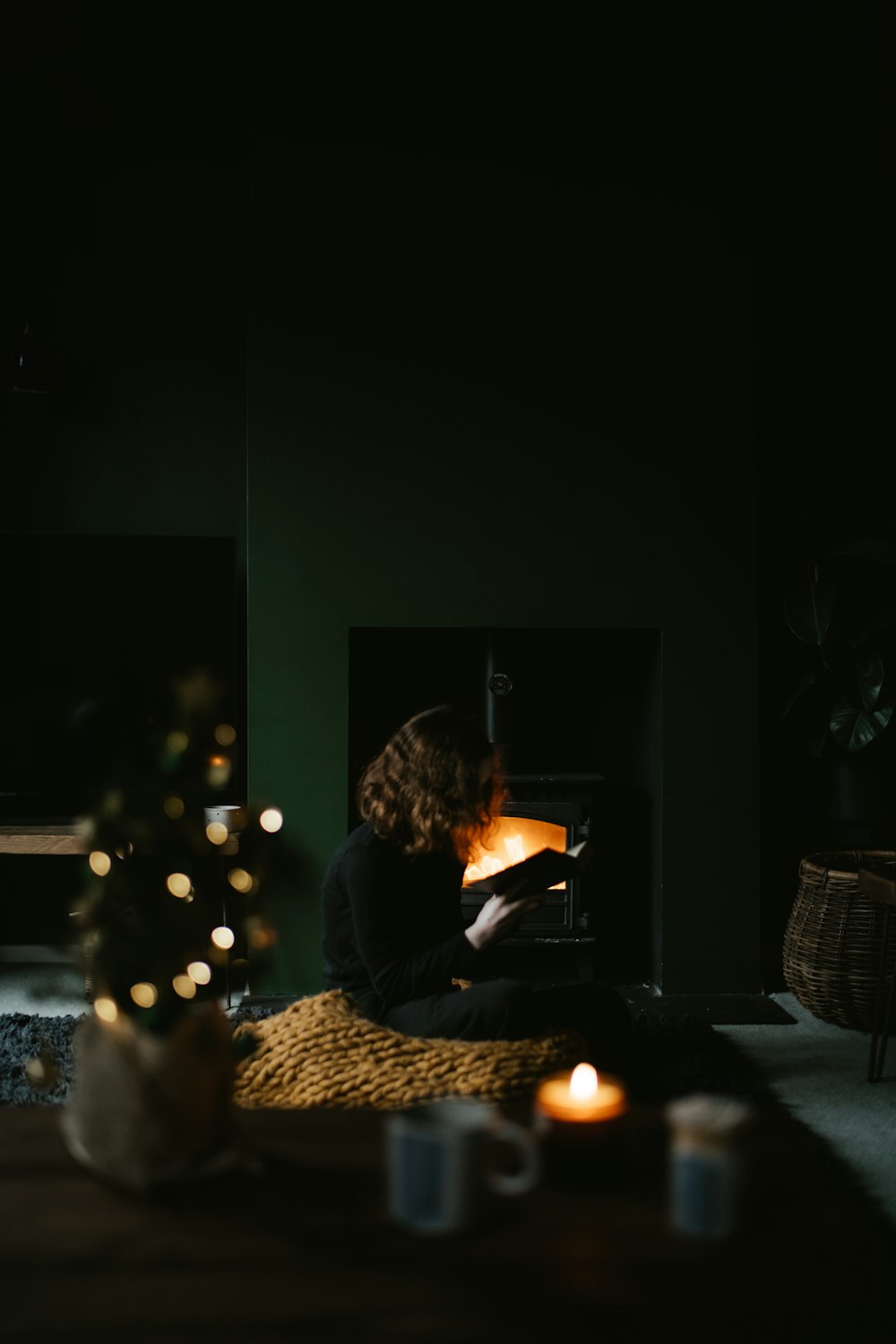 a woman sitting on the floor in front of a fireplace