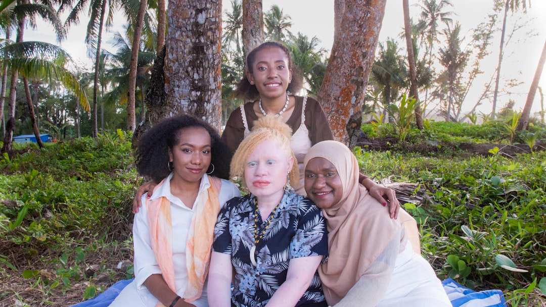 a group of women sitting next to each other on a blanket,