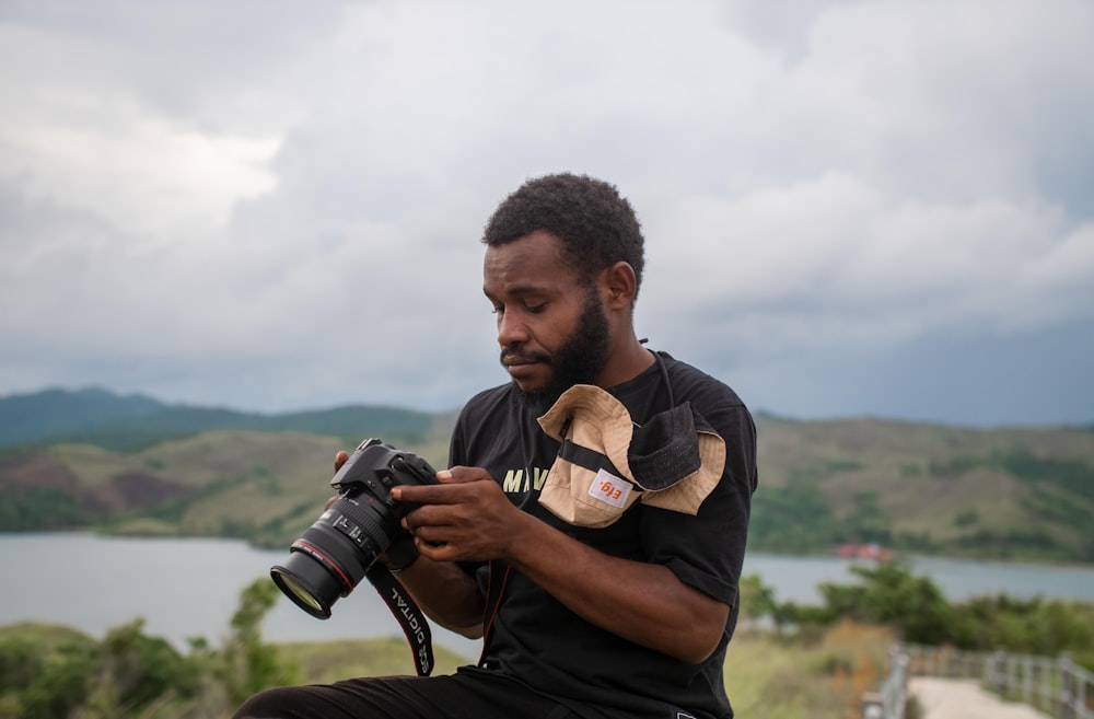 a man sitting on a rock holding a camera