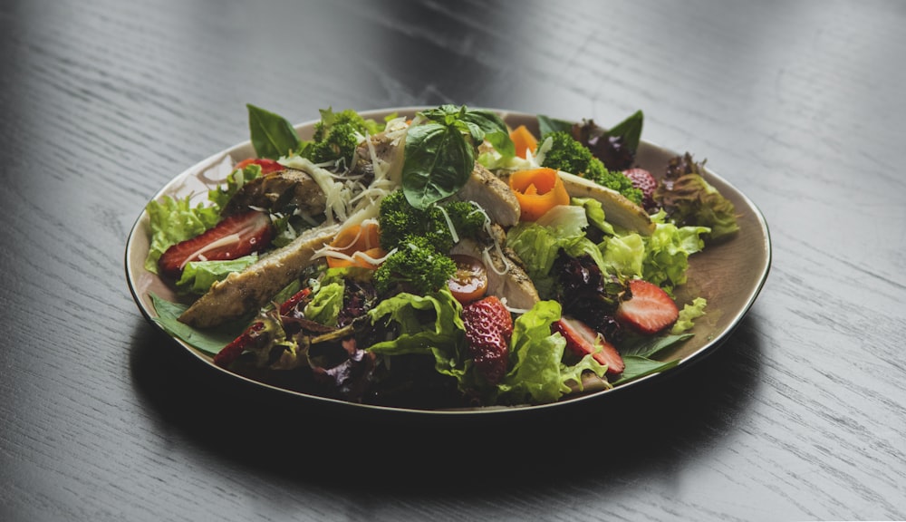a plate of salad on a wooden table