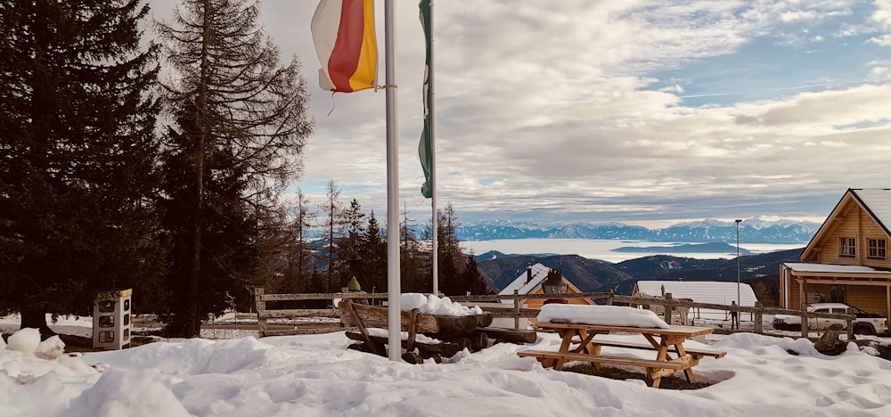 a picnic table with a flag on top of it in the snow