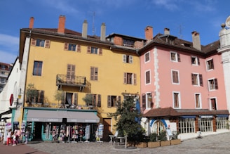 A cozy European street scene with colorful buildings and people enjoying a sunny day.