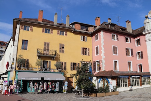 A cozy European street scene with colorful buildings and people enjoying a sunny day.