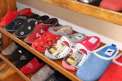 Soft cotton slippers lined neatly on a shelf displaying various sizes and styles.