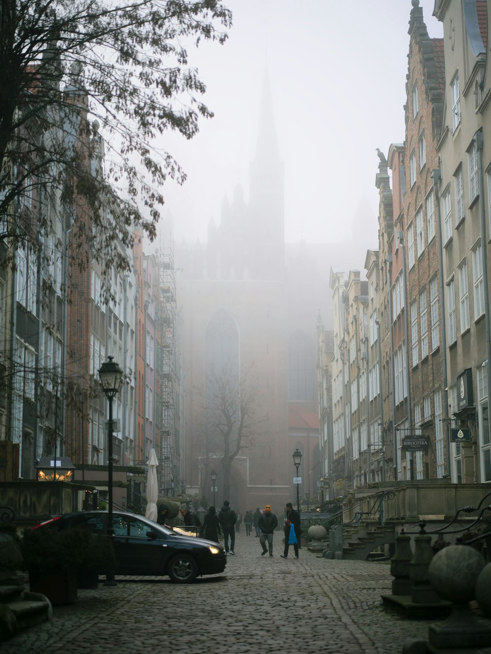 a group of people walking down a cobblestone street