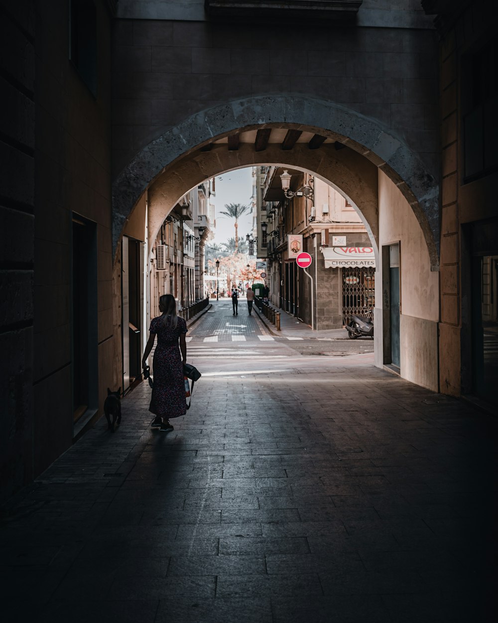 a woman walking down a dark alley way