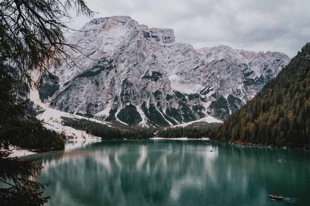 a lake surrounded by mountains in the middle of a forest