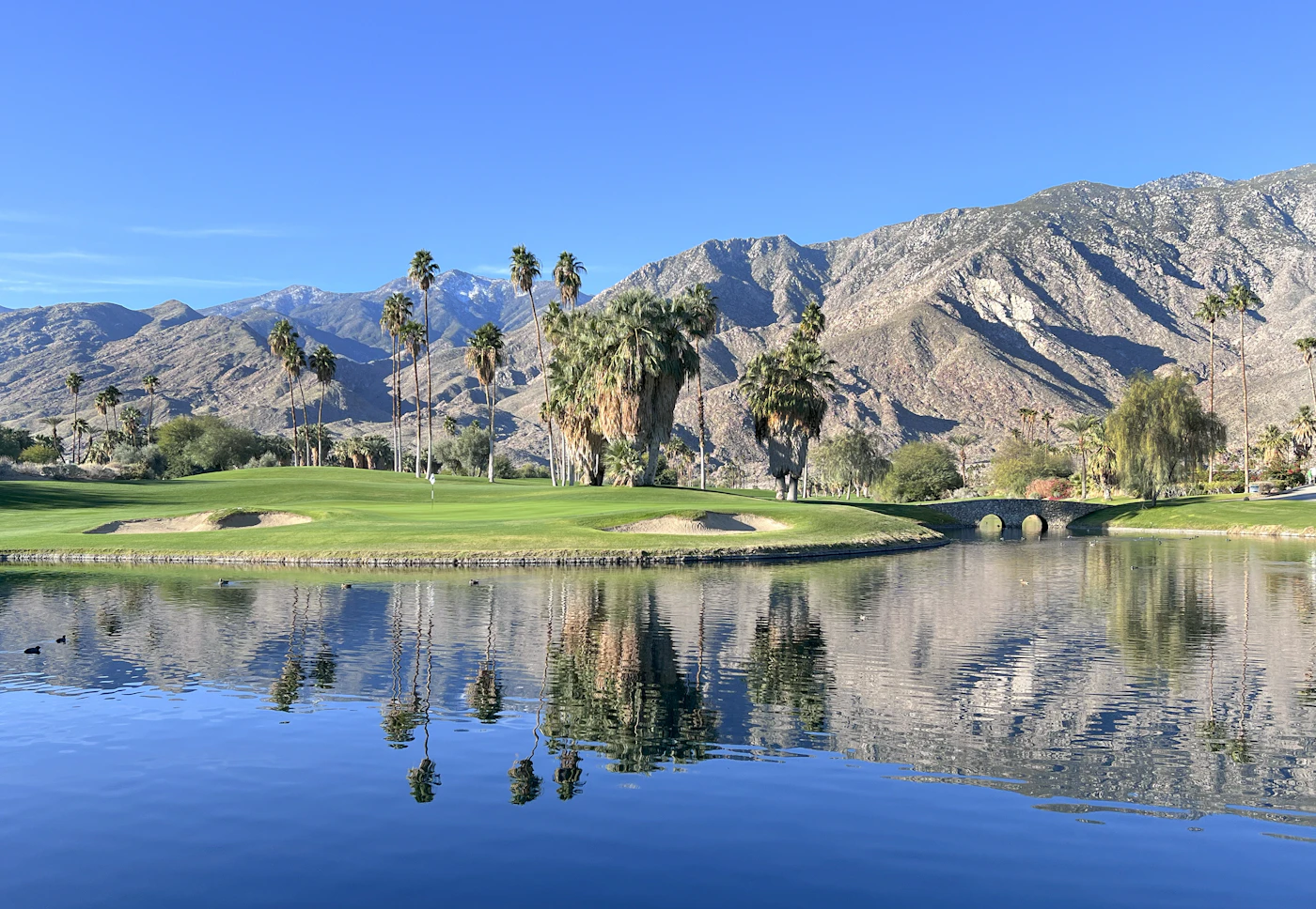 Golf course with a lake and mountains behind
