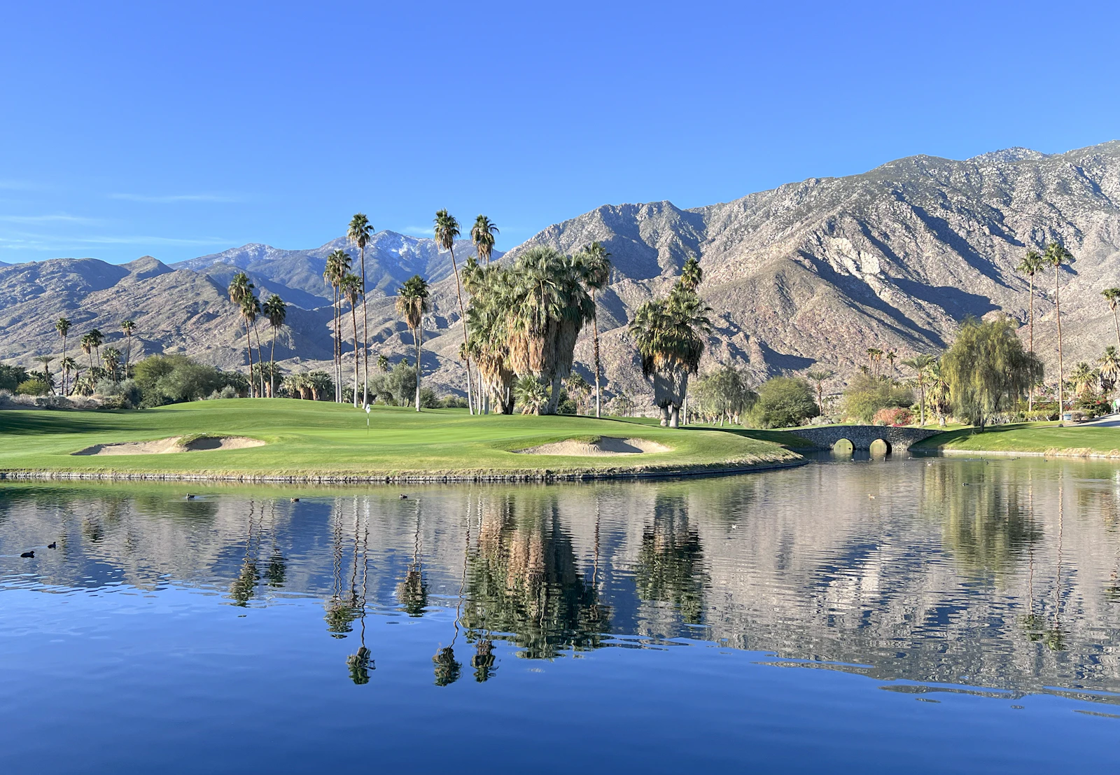 Palm Springs desert golf course with a lake and San Jacinto Mountains beyond