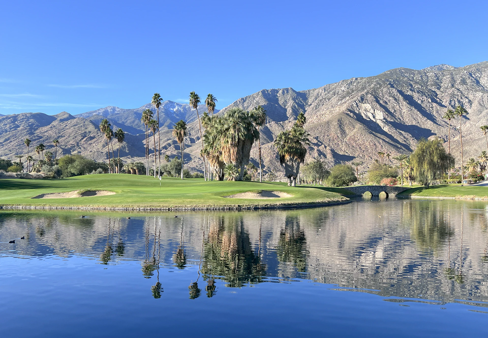 Golf course with a lake and mountains behind