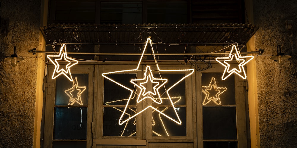 a lighted star hanging from the side of a building