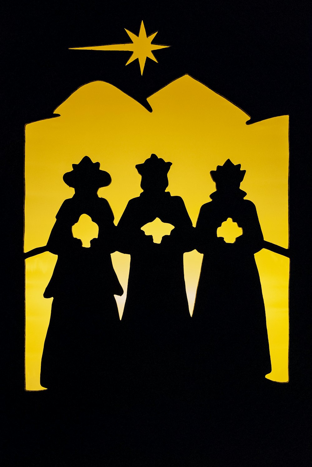 Una sagoma di tre persone in piedi di fronte a una stella