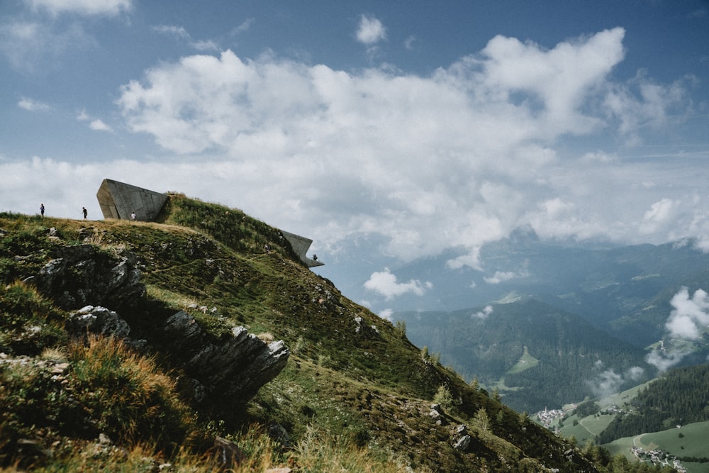 a grassy hill with a bench on top of it